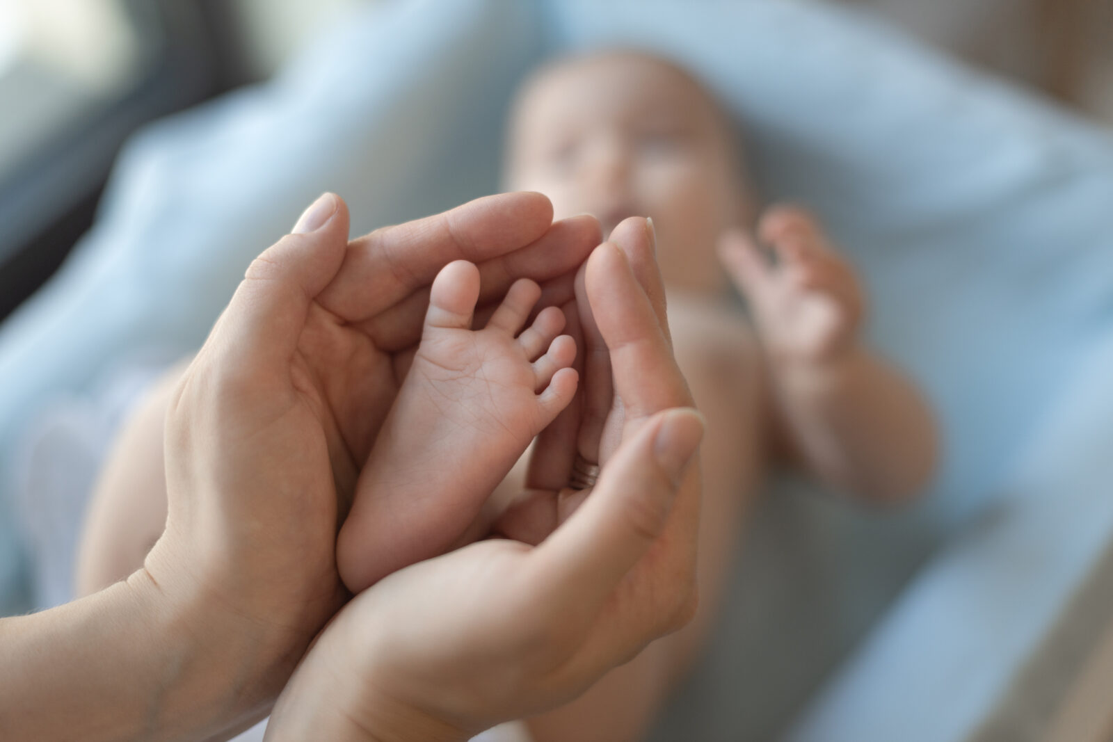 sweet baby foot in mom's hands. Mother massaging her child's foot,