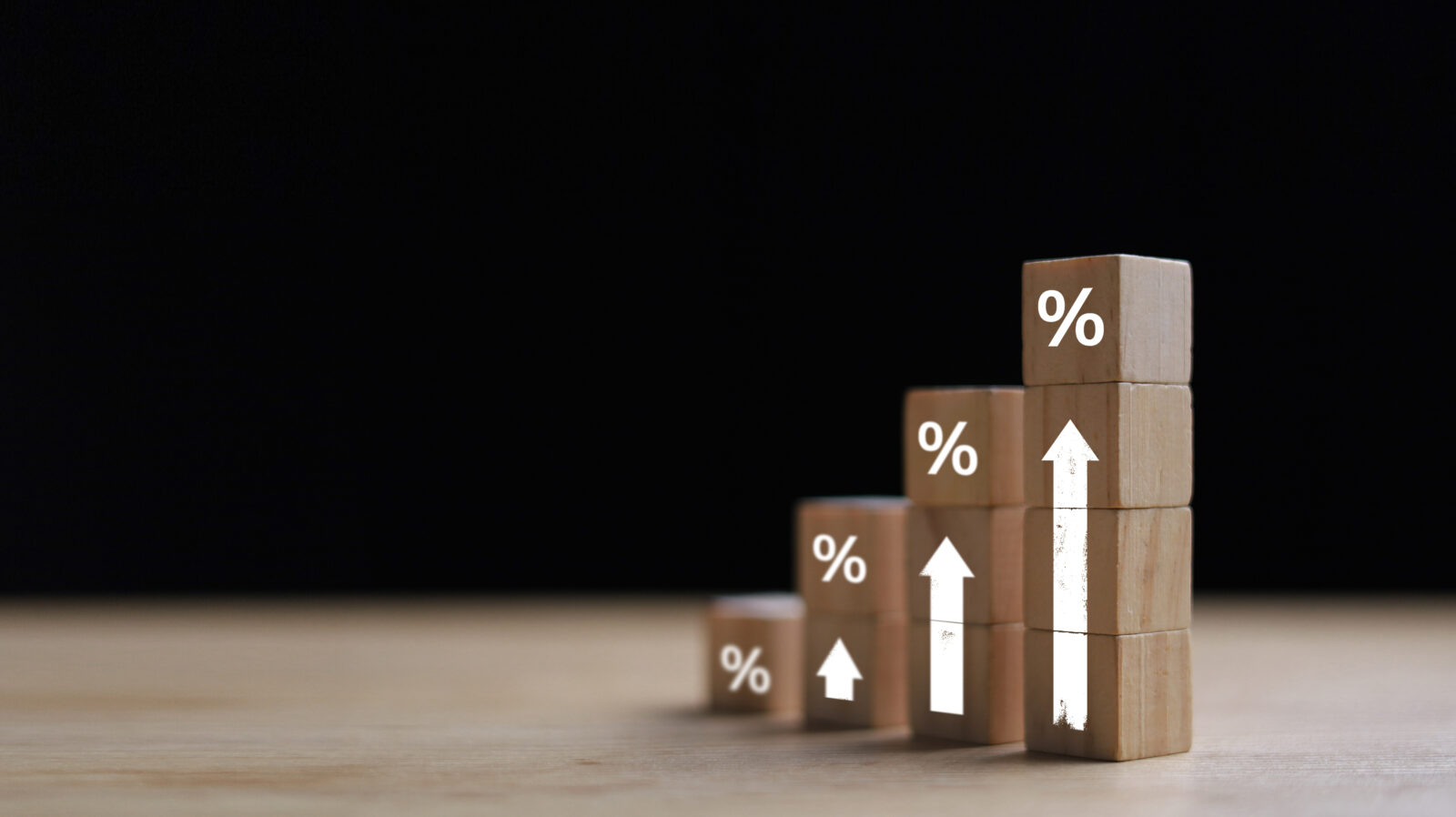 Wooden blocks with percentage signs showing an upward trend, concept of interest growth.