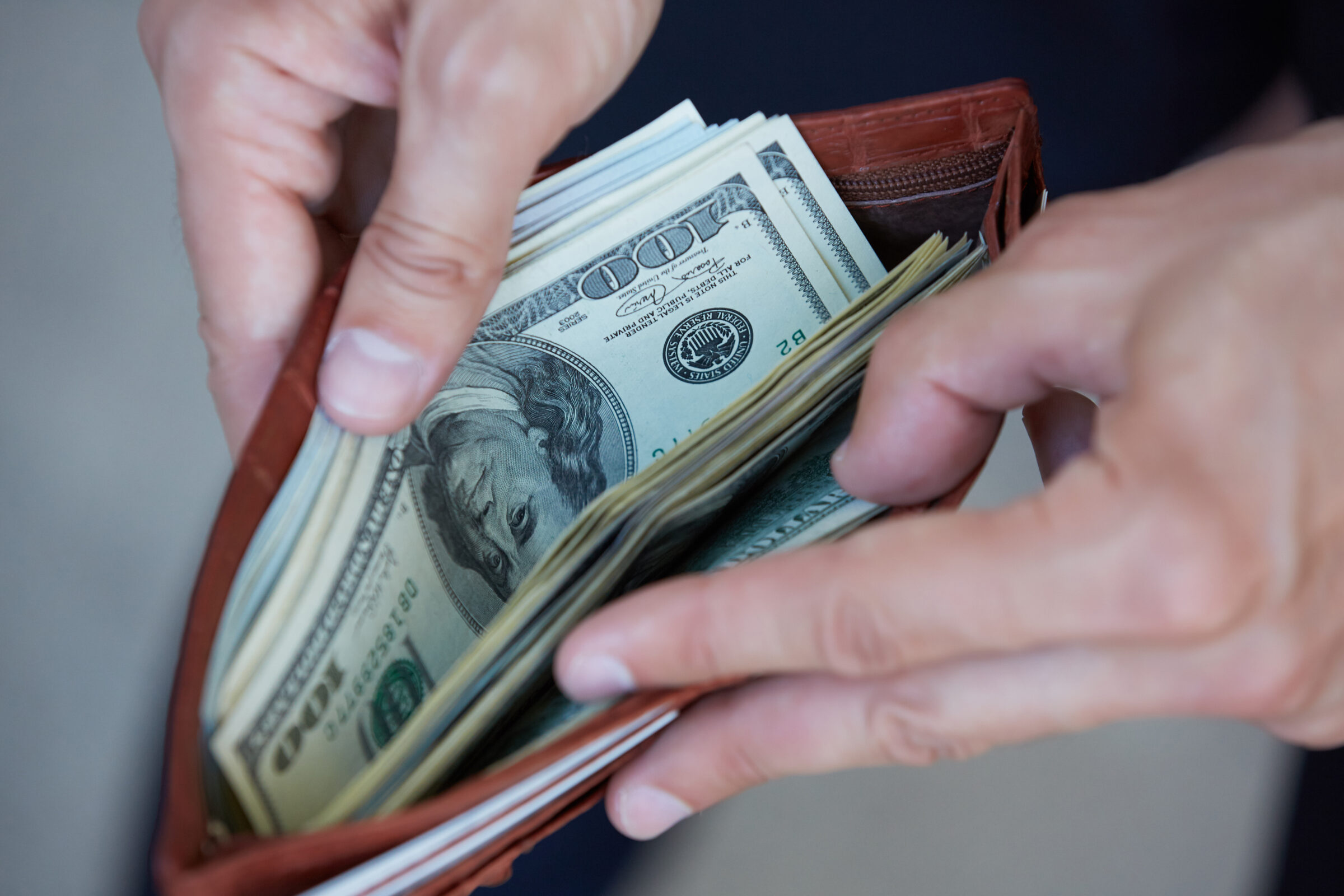 man holding a purse with money closeup