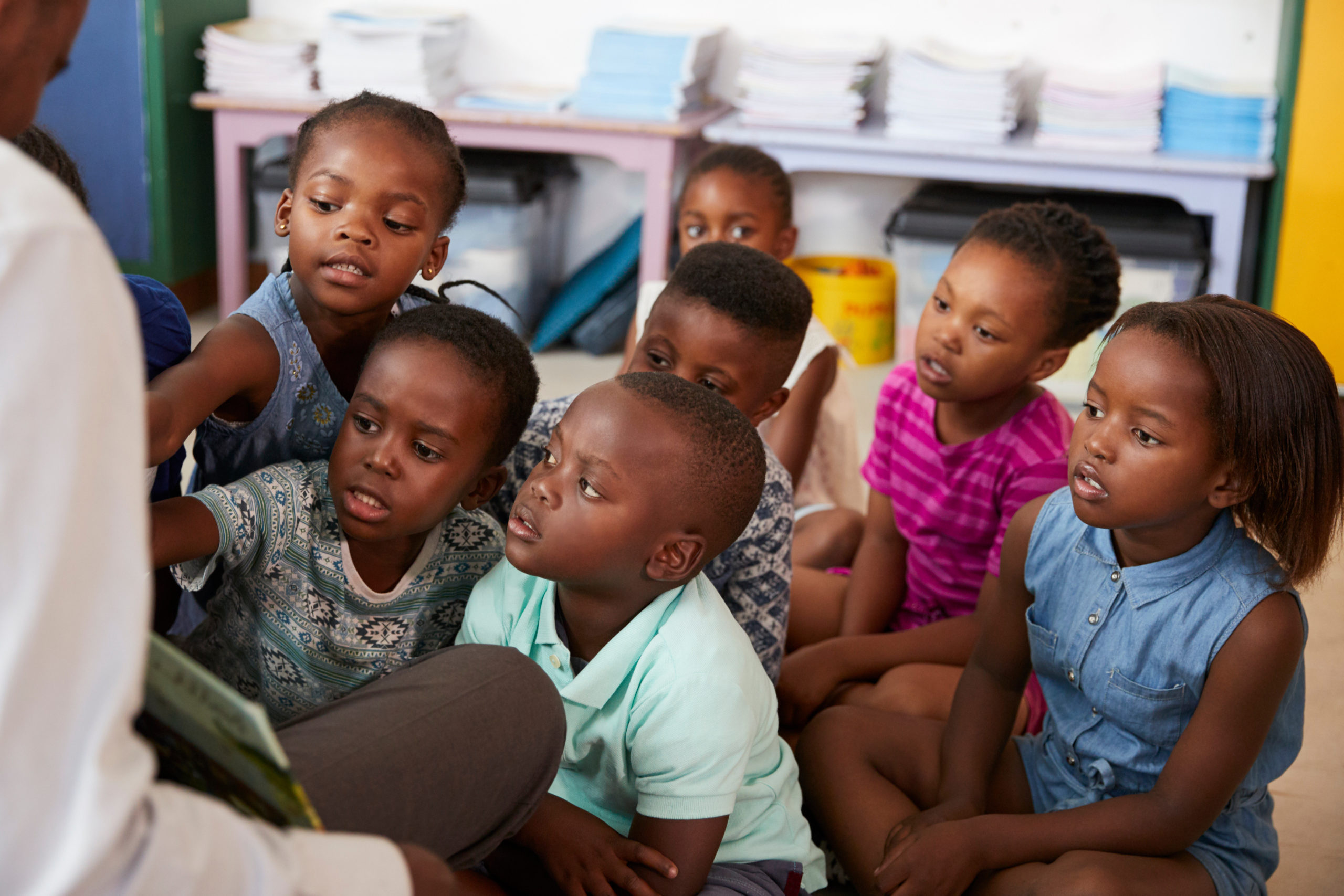 Teacher reading book to elementary school children in class