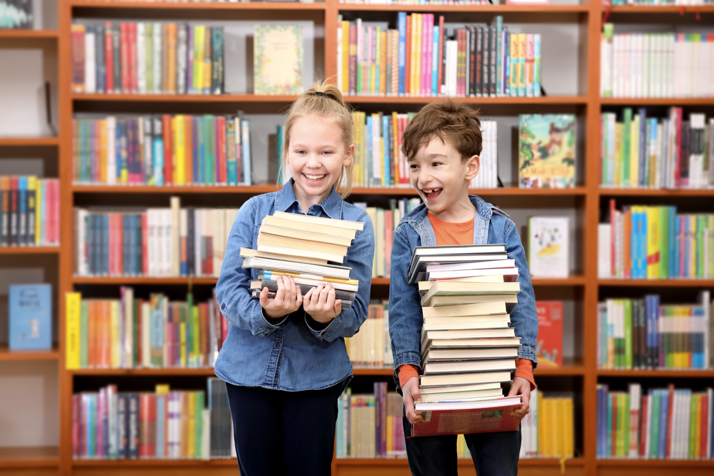 Cute boy and girl  reading book in library