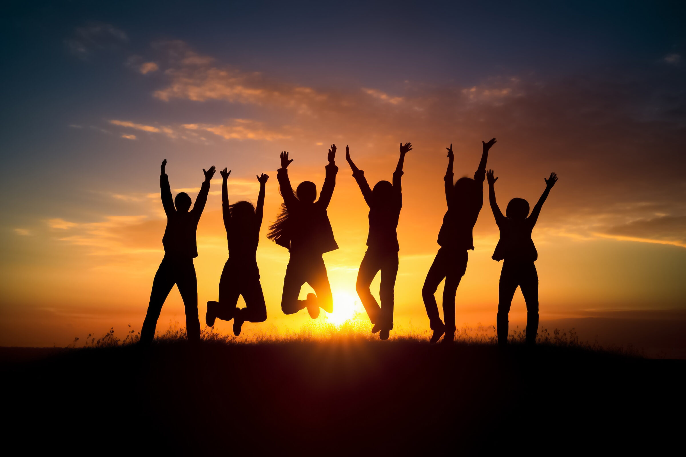 Big group of people having fun in success victory and happy pose with raised arms on mountain top against sunset lakes and mountains. Generative AI.